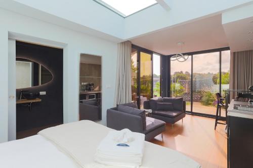 une chambre avec un lit et un salon dans l'établissement Ecolodge à 300m de la plage, à Pléneuf-Val-André