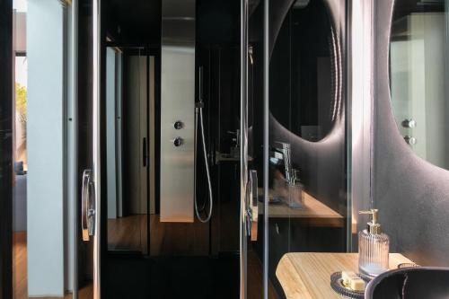 a bathroom with a glass shower and a wooden table at Ecolodge à 300m de la plage in Pléneuf-Val-André
