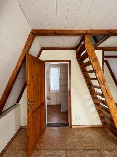 a room with a staircase and a bathroom in a attic at Finnhütte nah am Strand 