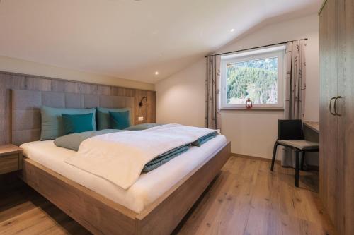 a bedroom with a large bed and a window at Balbeinhof Apt Hirsch in Luson