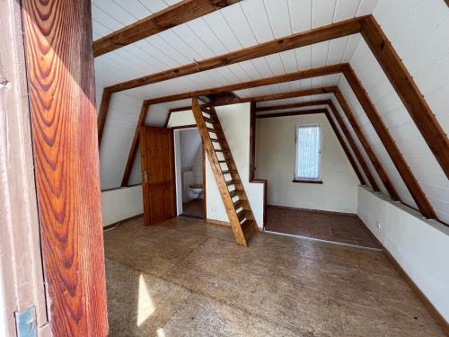 an attic room with a wooden ladder in it at Finnhütte nah am Strand 