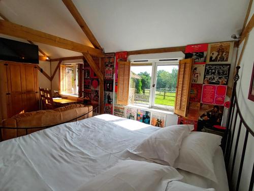 a bedroom with a large white bed and a window at The Music Room - Kingsize Double - Sleeps 2 - Quirky - Rural in Haslemere