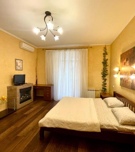 um quarto com uma cama grande e uma televisão em Бакулина 14 em Kharkov