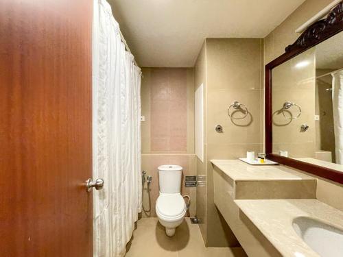 a bathroom with a toilet and a sink and a mirror at Haveli Backwater Resort in Alleppey
