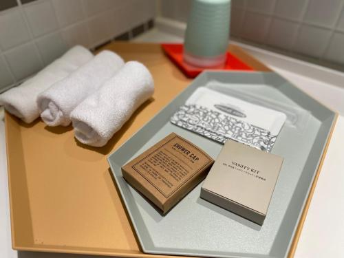 pudełko z ręcznikami i książka na stole w obiekcie Jeju Bricks Hotel w mieście Seogwipo