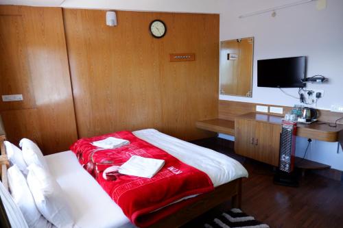 達旺鎮的住宿－Hotel Mon Paradise，一间墙上挂有时钟的床的房间
