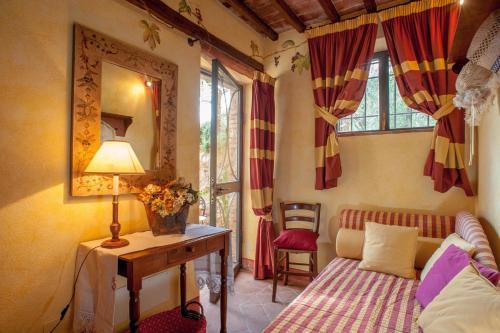 1 dormitorio con cama, mesa y espejo en Romantic farmhouse villa Pallina to sleep 5 guests, en Aquilea