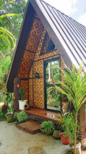 a small house with a window and some plants at LK Farmcation Cabin Ligaya - Lucban, Quezon in Nalunao