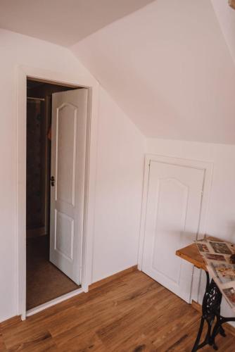 an empty room with a door and a table at Casa Bunicilor in Nucşoara
