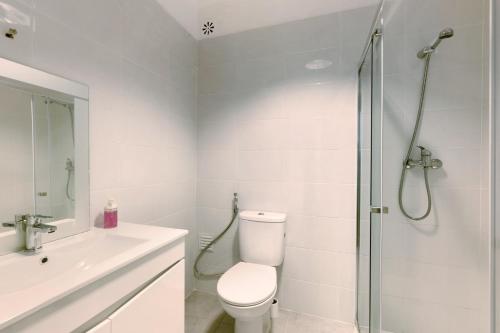 a white bathroom with a toilet and a shower at Cozy and Vintage Apartment in Carcavelos