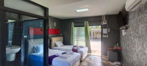 a bedroom with two beds and a sink and a mirror at changrojresortkaengkhoi in Kaeng Khoi