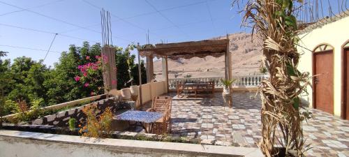 a patio of a house with a table and chairs at Tibs mountain view in Al Aqālitah