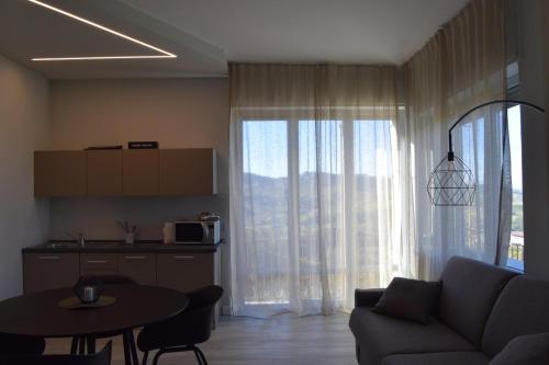 a living room with a couch and a table and a kitchen at Fenocchio's House in Castiglione Falletto