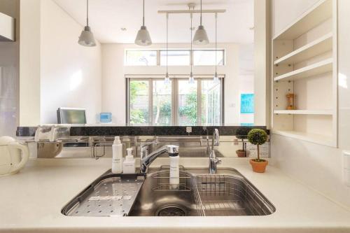 eine Küche mit Spüle und Fenster in der Unterkunft Okusawa Private House in Tokio