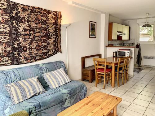 un salon avec un canapé bleu et une table dans l'établissement Duplex avec terrasse près de la plage et commerces - Saint-Pair-sur-Mer - FR-1-361-374, à Saint-Pair-sur-Mer