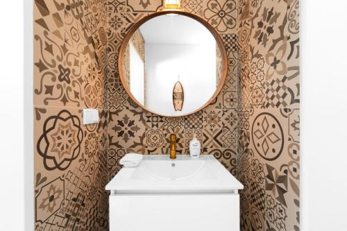 W łazience znajduje się umywalka i lustro. w obiekcie Panoramic Views - Terrace, Sea Views & Pool w mieście Nazaré