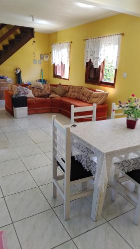 een woonkamer met een tafel en een bank bij Casa de praia para família - 3 quartos - acomoda até 10 pessoas in Tramandaí