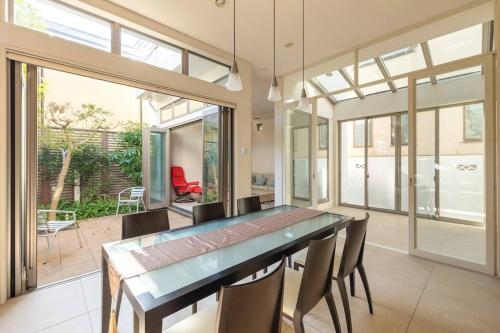 a dining room with a glass table and chairs at Okusawa Private House in Tokyo