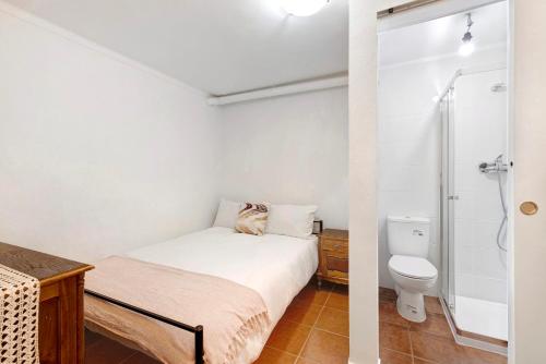 1 dormitorio con cama, ducha y aseo en Cozy and Vintage Basement en Carcavelos