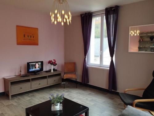 uma sala de estar com uma televisão e uma janela em Le Cormoran em Le Tréport