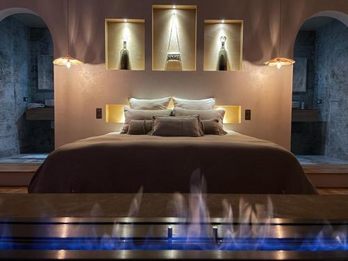 イストルにあるMas Escala Suites & Spaのベッドルーム1室(壁に照明付きの大型ベッド1台付)