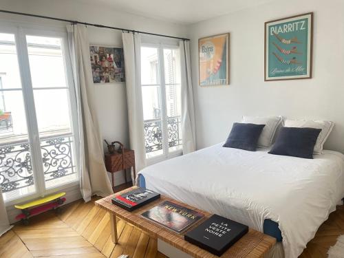 ein Schlafzimmer mit einem Bett und einem Tisch mit Büchern in der Unterkunft Au pied de Montmartre in Paris