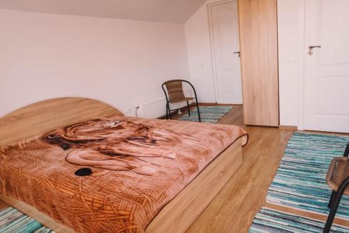 a bedroom with a bed and a chair in it at Casa Bunicilor in Nucşoara