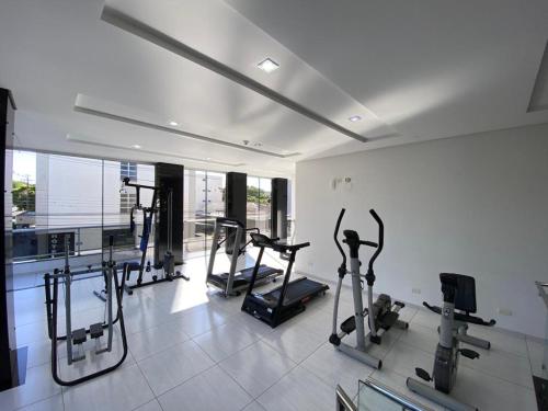 a gym with several tread machines in a room at Grande Hotel in Paranavaí