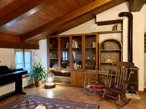 a living room with a piano and a chair at Appartamento immerso nella natura, silenzio e riservatezza a 550 m di quota in Langhirano