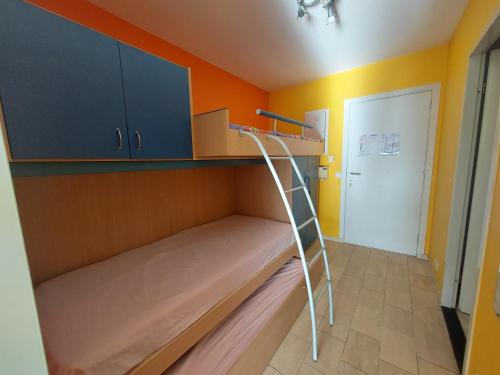 a bunk bed with a ladder in a room at Studio Zeedijk Koksijde in Koksijde