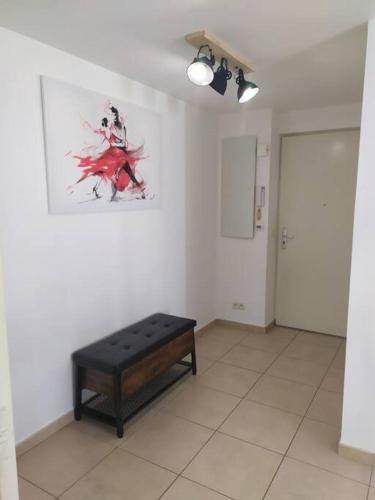 a room with a bench and a painting on the wall at Beau studio neuf + parking et vélo gratuit in Pérols