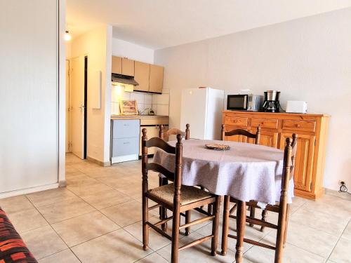 une cuisine avec une table et des chaises dans une pièce dans l'établissement Studio cabine à Banyuls-sur-Mer, terrasse, parking privé, proche centre-ville et plage - FR-1-309-277, à Banyuls-sur-Mer