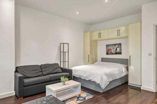 uma sala de estar com uma cama e um sofá em Cosy & Modern Studio em Londres