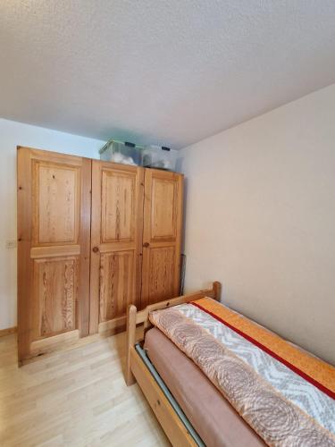 a bedroom with a bed and wooden cabinets at Haus Rizzi in Bivio