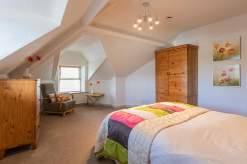 ein Schlafzimmer mit einem Bett, einer Kommode und einem Stuhl in der Unterkunft Stonyhurst Spacious apartment, great location. in Clitheroe