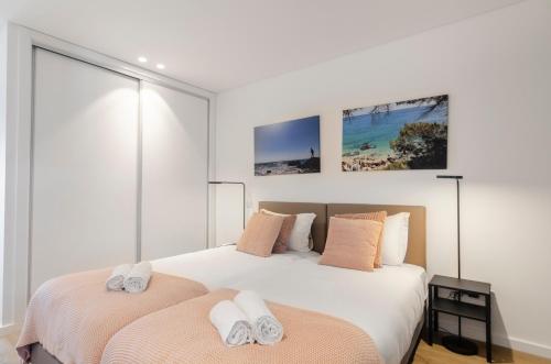 een slaapkamer met twee bedden met handdoeken erop bij Panoramic Views - Terrace, Sea Views & Pool in Nazaré