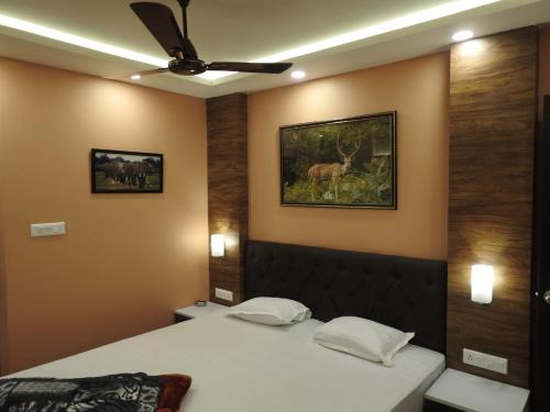 1 dormitorio con 2 camas y ventilador de techo en hp greenland resort, en Lataguri