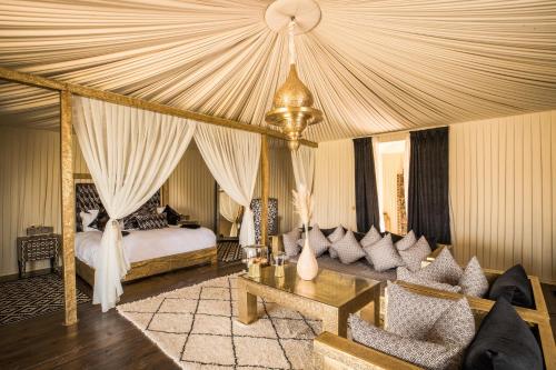 拉拉塔可豪斯特的住宿－Kalyptus Luxury Camp，一间带天蓬床的卧室和一间客厅