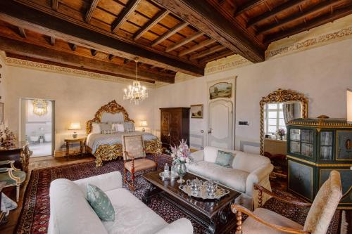 a living room with a bed and a couch at Castello di Casalborgone, Luxury Italian Castle Hotel in Casalborgone