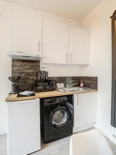 une cuisine avec une machine à laver et un lave-linge dans l'établissement L'horloge II - 2 pièces - 15 min Palais - Cannes, à Cannes