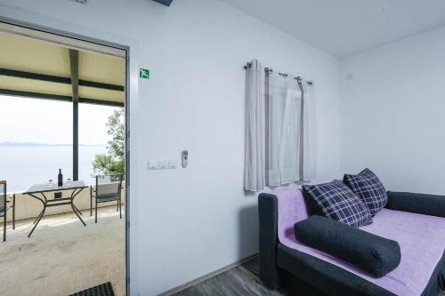 a living room with a purple couch and a view of the ocean at Robinson Dingac in Gornji Dingač