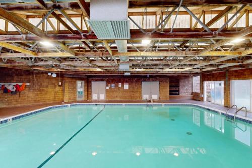 a large swimming pool with blue water in a building at Beautiful Briny Retreat in Newport
