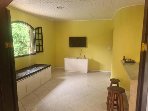 un soggiorno con pareti gialle e TV di Recanto do Valdir ad Angra dos Reis