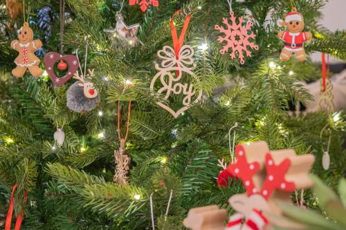 ein Weihnachtsbaum mit Weihnachtsornamenten darauf in der Unterkunft The Bolt Hole -Luxury 3 bed cottage with hot tub! Silverdale in Silverdale
