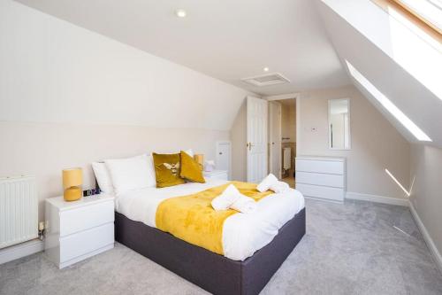 a white bedroom with a large bed with yellow sheets at The Cottage at Gildridge + Private Hot tub in Lewes