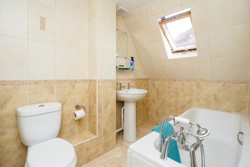 a bathroom with a toilet and a sink and a tub at The Cottage at Gildridge + Private Hot tub in Lewes