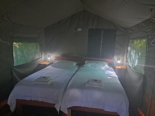 a bedroom with a bed in a tent at Woodcutter's Bush Camp at The Old Trading Post in Wilderness