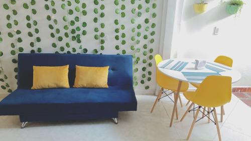 Sofá azul en la sala de estar con mesa en habitacion privada en Jardin cerca al parque, en Jardín