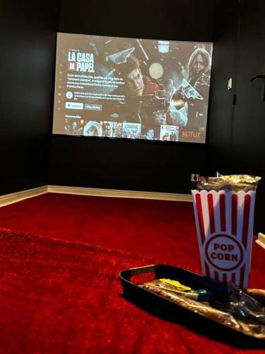 a table with a tray of popcorn and a box of soda at Le Cosy'ppart - EasyLife in Bourgoin
