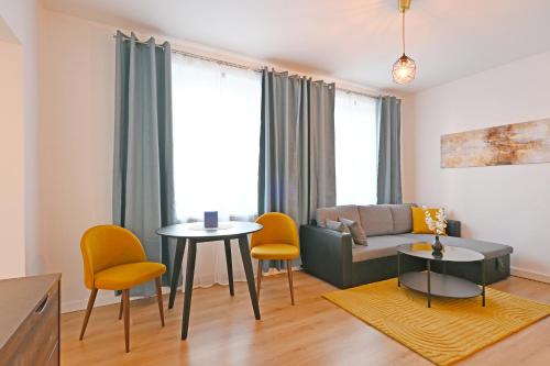 a living room with a couch and a table and chairs at Gemütliches Stadtapartment im Zentrum von Ried im Innkreis in Ried im Innkreis